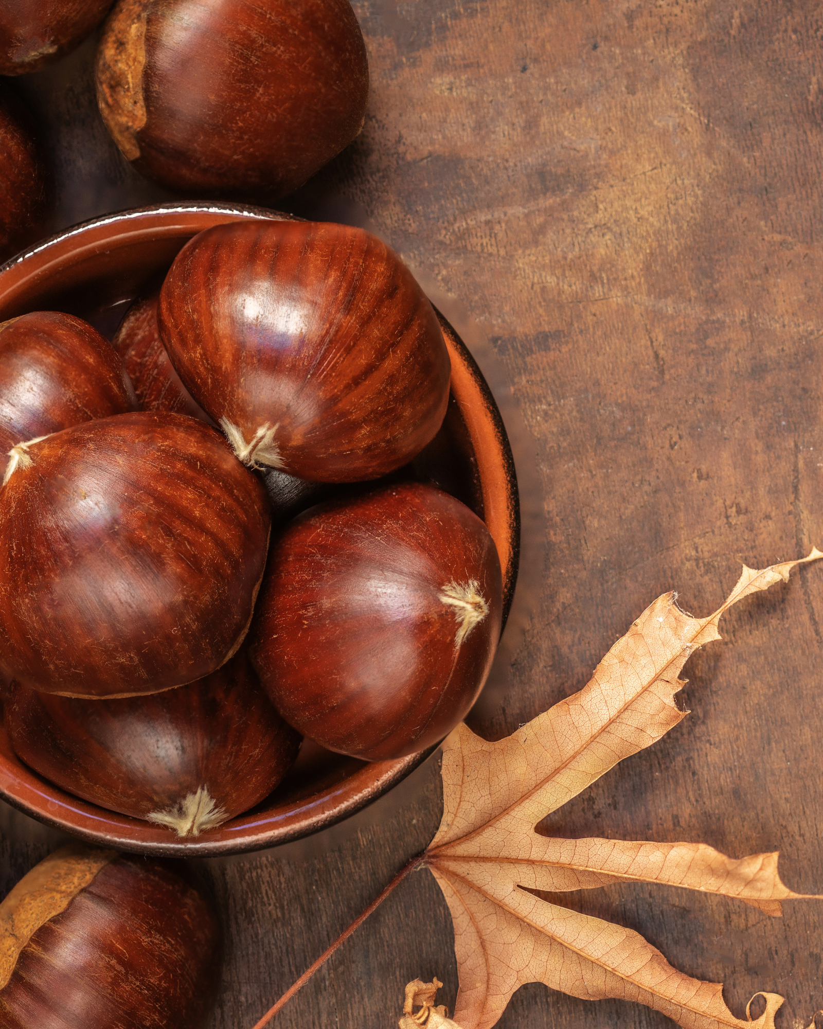 Chestnuts on a bowl on a birch tabletop. Chestnut & Birch fragrance oil by Scentivore. For soap and candle-making. 