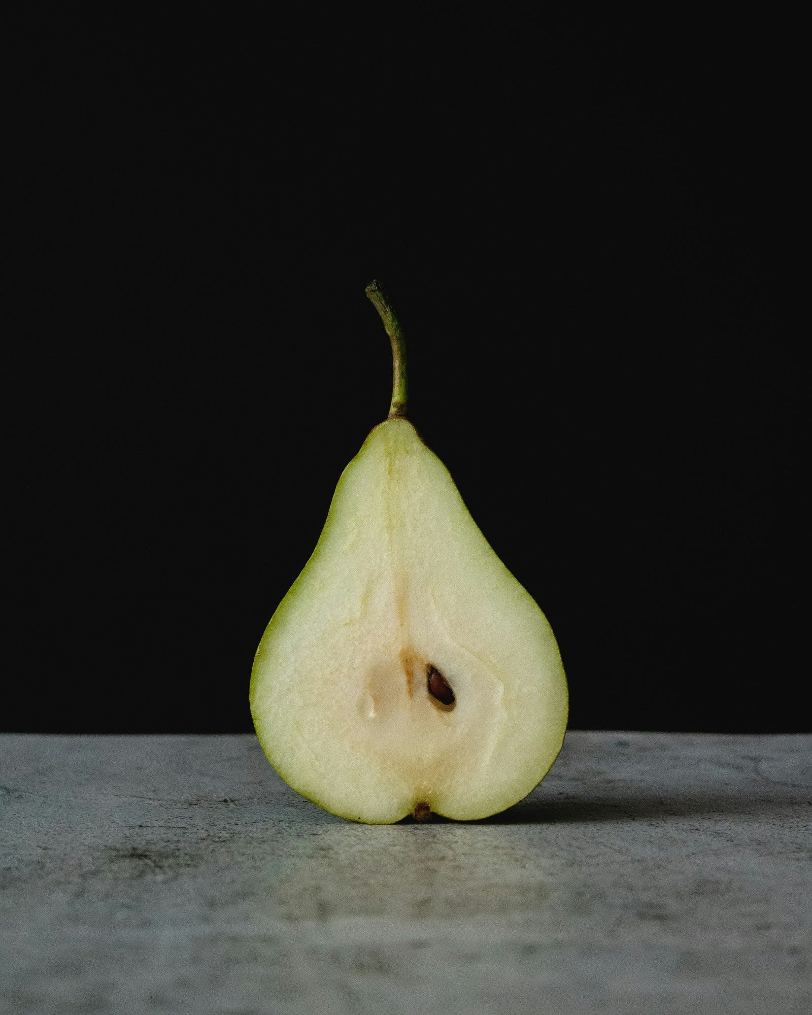 A sliced in half pear. Green Anjou Pear fragrance oil by Scentivore. 